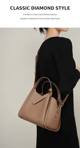 Dettaglio borsa a secchiello in pelle marrone a grana litchi con accessori in oro lucido