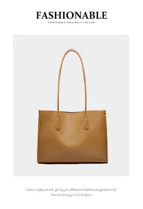 Detalle del bolso tote de cuero marrón con textura suave y asas largas delgadas