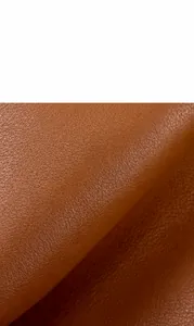 Close-up of caramel brown genuine cowhide leather with a high-quality pebble grain texture