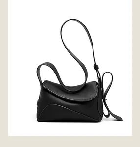 Détail de la texture en cuir grainé noir et de la structure ondulée du sac à main
