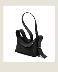 Détail d'un sac bandoulière en cuir grainé noir avec bandoulière en S et boucle argentée