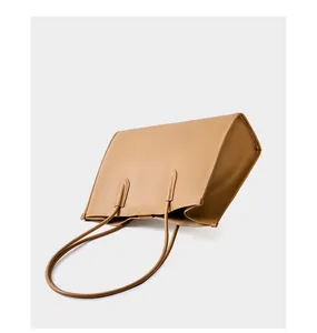 Vista detallada del bolso tote de cuero caqui con textura suave y asas largas al hombro
