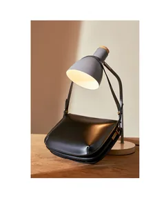 Detail of glossy black leather handbag showing elegant golden hardware and smooth texture