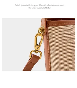 Macro detail of beige woven texture with brown leather edges and gold metal clasp