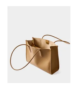 Detalle del interior del bolso tote de piel beige con bolsillos y cierre magnético