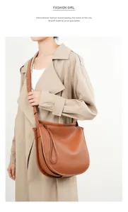 Detailed view of brown leather tote bag with soft texture and adjustable strap on a model