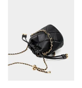 Detail der schwarzen gesteppten Beuteltasche aus Kalbsleder mit goldener Kette