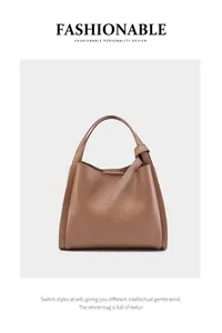 Dettaglio della borsa a secchiello in pelle marrone con nodo decorativo sul manico curato