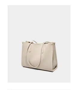 Detalle del cuero blanco crema con textura de lichi y costuras precisas en el bolso de mano