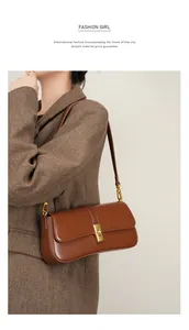 Close-up of caramel leather baguette bag with gold twist lock on herringbone blazer