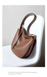 Close-up of caramel leather hobo bag showing litchi grain texture and silver zipper detail