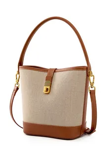 Minimalist canvas and leather bucket bag with gold twist lock and adjustable strap