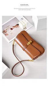 Detail view of brown leather shoulder bag with elegant gold buckle and long strap