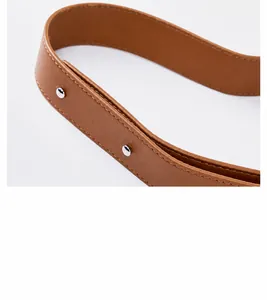 Detail of brown litchi pattern leather strap with silver rivets and neat stitching