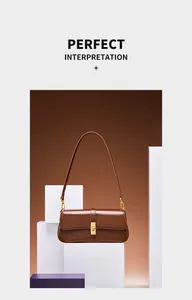 Detail of dark brown leather baguette bag with golden metal buckle on geometric stand