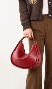 Detail of the deep red hobo bag showing the high-quality matte leather and metal buckle