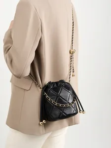 Elegante schwarze gesteppte Leder Beuteltasche mit Goldkette am Model gezeigt