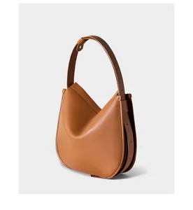 Macro detail of camel leather tote showing V-shape folding structure and wide strap