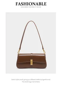 Detailed view of brown leather baguette bag with elegant gold buckle and smooth finish