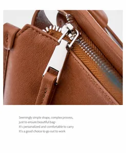 Detailed macro view of silver metal zipper and stitching on caramel leather tote bag