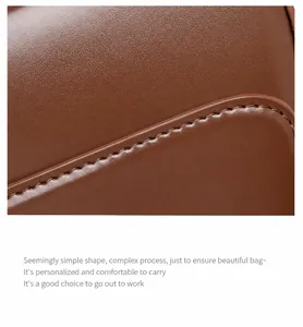 Macro shot of dark brown genuine leather showing fine stitching and smooth edges on the bag