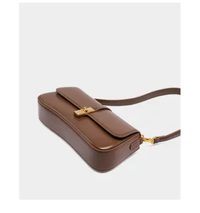 Detailed view of dark brown leather baguette bag featuring a gold rectangular twist lock