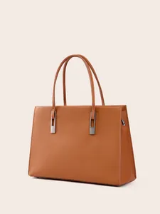 Elegante Handtasche aus karamellfarbenem Leder mit Lychee-Struktur und silbernen Beschlägen