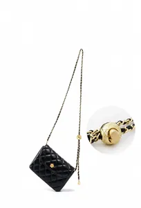 Close-up of adjustable gold ball latch on a black quilted leather bag with chain