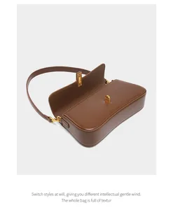 Detail view of the spacious interior and golden hardware on the brown leather baguette bag