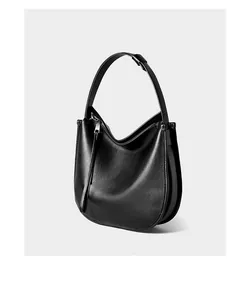 Detailed close-up showing the smooth texture and wide strap of the black leather hobo bag