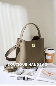 Dettaglio borsa a secchiello in pelle martellata color talpa con chiusura a scatto dorata
