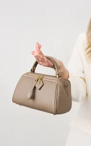 Close-up of pebble grain leather Boston bag with gold hardware and dual zippers
