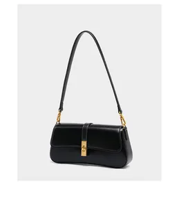 Detail of black leather bag showing the golden square twist lock and smooth texture