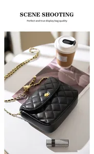 Detail of black quilted leather shoulder bag with gold floral clasp and metal chain