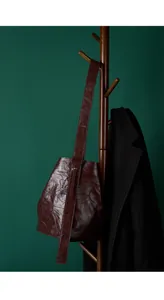Nahaufnahme der dunkelrotbraunen Beuteltasche mit faltiger Echtleder-Textur im Retro-Stil