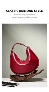 Detail view of burgundy crescent shoulder bag with smooth leather and top zipper