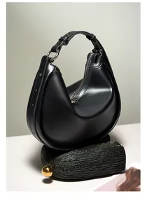 Detailed view of black crescent hobo bag with adjustable buckle strap and silver hardware