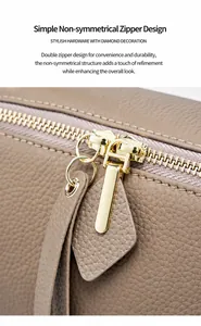 Detailed close-up of golden dual zippers and lychee grain leather on a Boston bag
