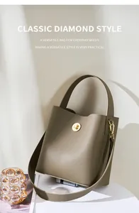 Dettaglio della borsa a secchiello in pelle grigio-verde con chiusura a scatto dorata