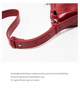 Close-up of adjustable strap and red leather texture on a crescent shoulder bag