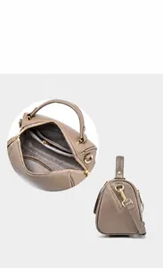 Macro detail of khaki leather Boston bag with creative diagonal zipper and metal hooks