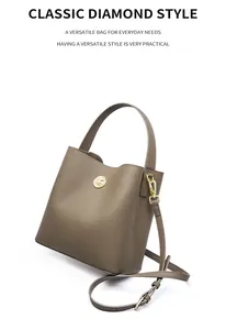 Dettaglio borsa a secchiello in pelle taupe con logo dorato e fibbia regolabile