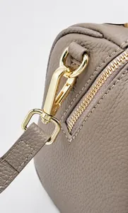 Macro detail of high-gloss light gold hardware and lychee grain leather texture