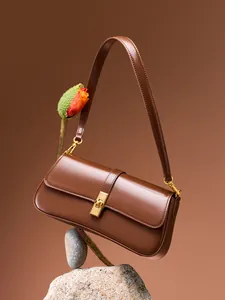 Brown leather baguette shoulder bag with gold twist lock and adjustable strap