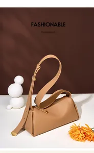 Détail du sac polochon en cuir camel avec ferrures dorées et bandoulière réglable