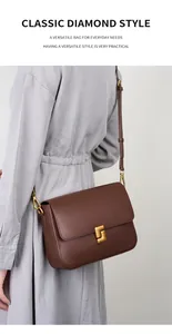 Detail of dark brown leather crossbody bag featuring a classic gold geometric buckle