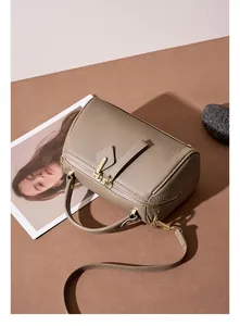 Top-down view of taupe lychee grain leather Boston bag with gold hardware and stone decor