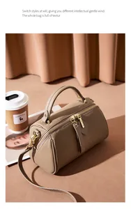 Detail of khaki pebbled leather Boston bag with gold hardware and dual zipper closure