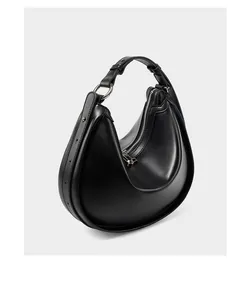 Detail view of the black crescent hobo bag with silver metallic hardware and adjustable strap