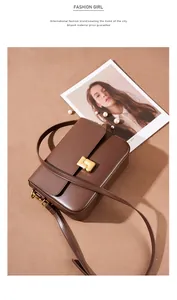 Detail of a brown leather shoulder bag with a rectangular gold magnetic buckle closure